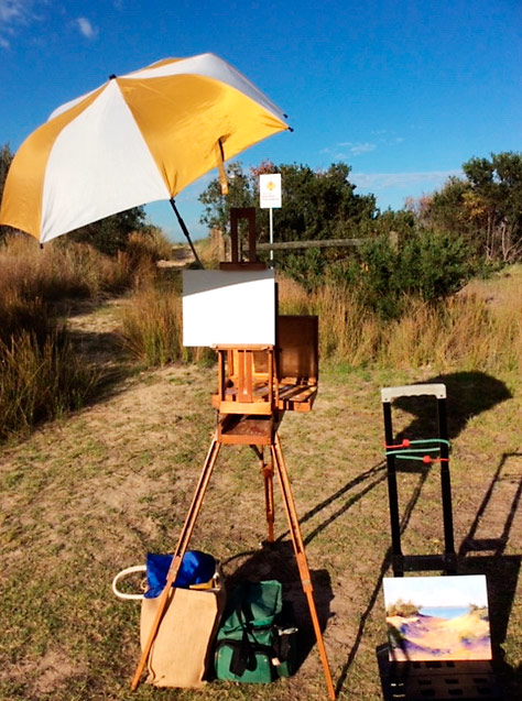 Plein air setup - easel, umbrella, painting, canvas, bags