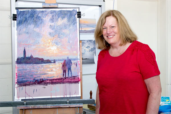 Pamela Pretthy with finished pastel painting of a sunset in Venice.