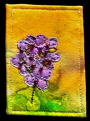 Artist trading card featuring a mauve flower on yellow green dyed background
