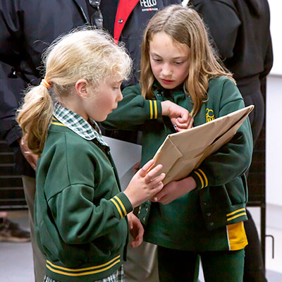 2022 Spring Art Show Childrens' Art Awards - two girls reading examining prize