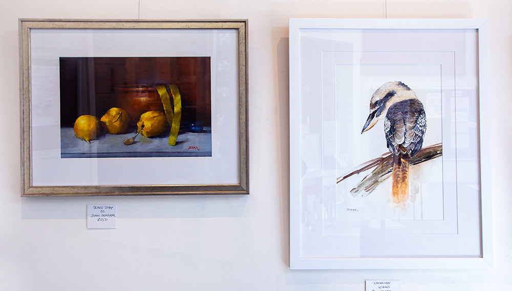 Artworks by Joan Denner, one still life in oils featuring gold coloured quinces and the other a watercolour of a kookaburra.