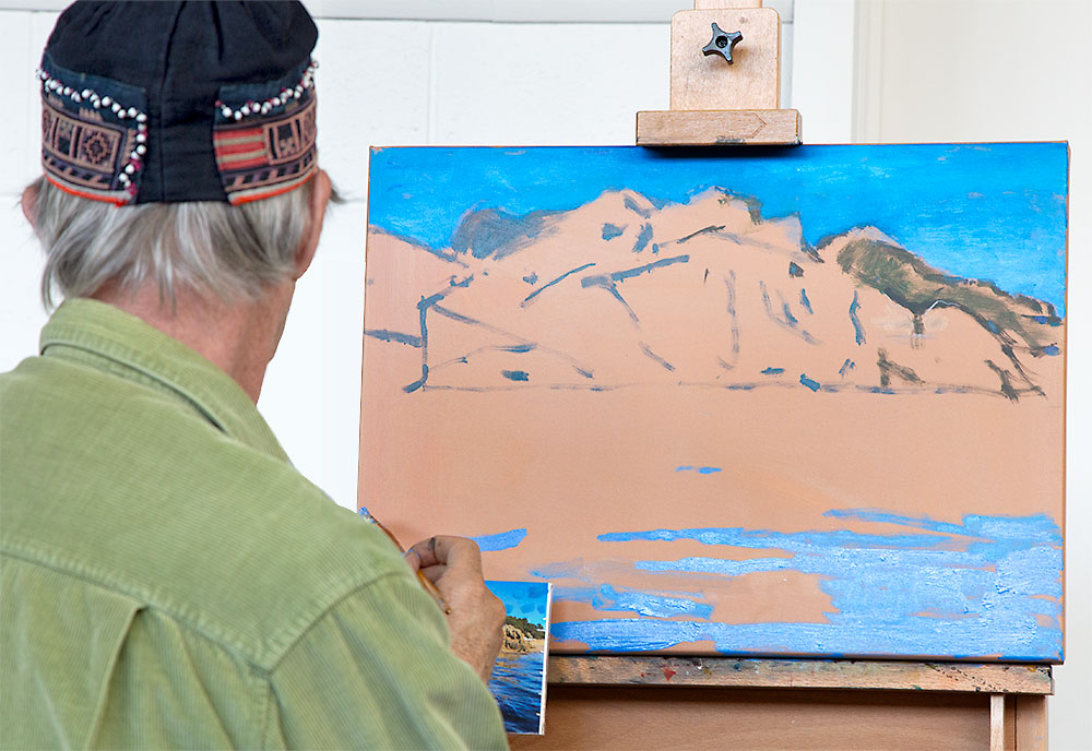 Rick Matear's acrylic painting demonstration of a sunny seascape with orange-yellow cliffs and bright blue rippled water.