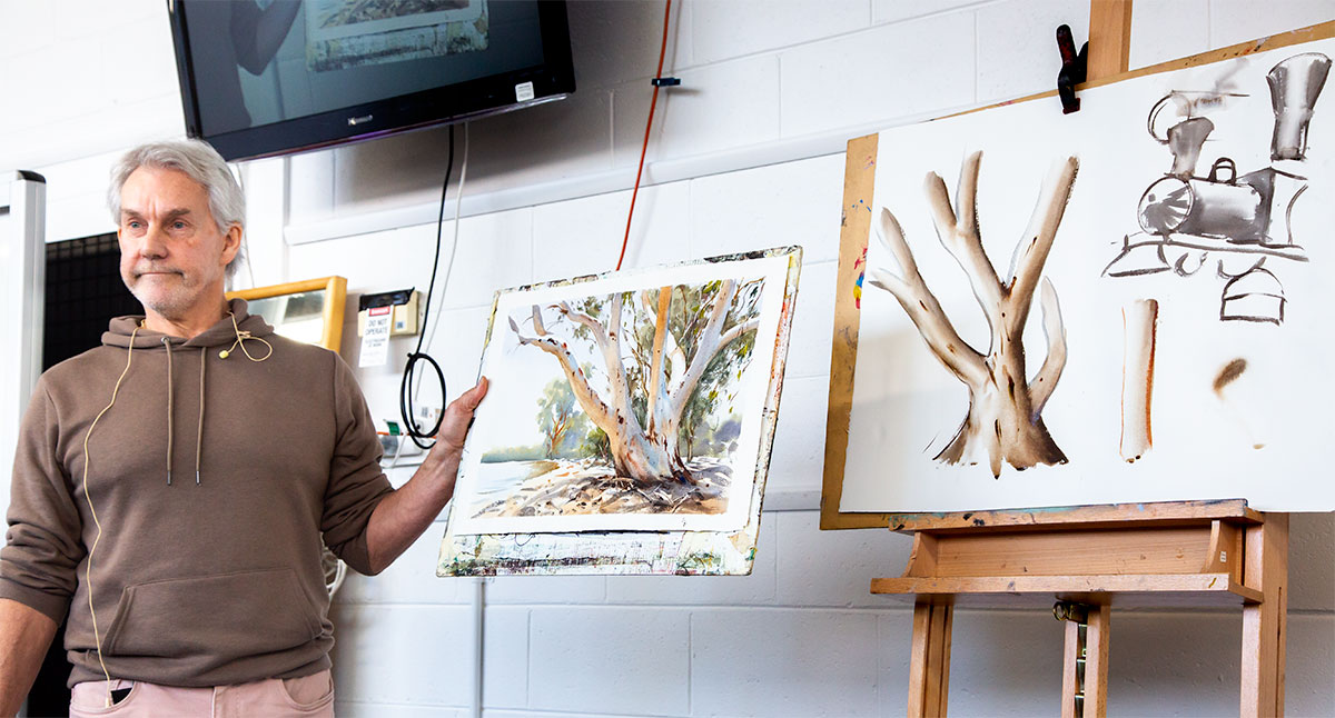 Explaining how trees can be thought of as a series of tubular forms. Showing a finished watercolour painting of a gum tree beside a simple tree shape consisting of tubular forms.