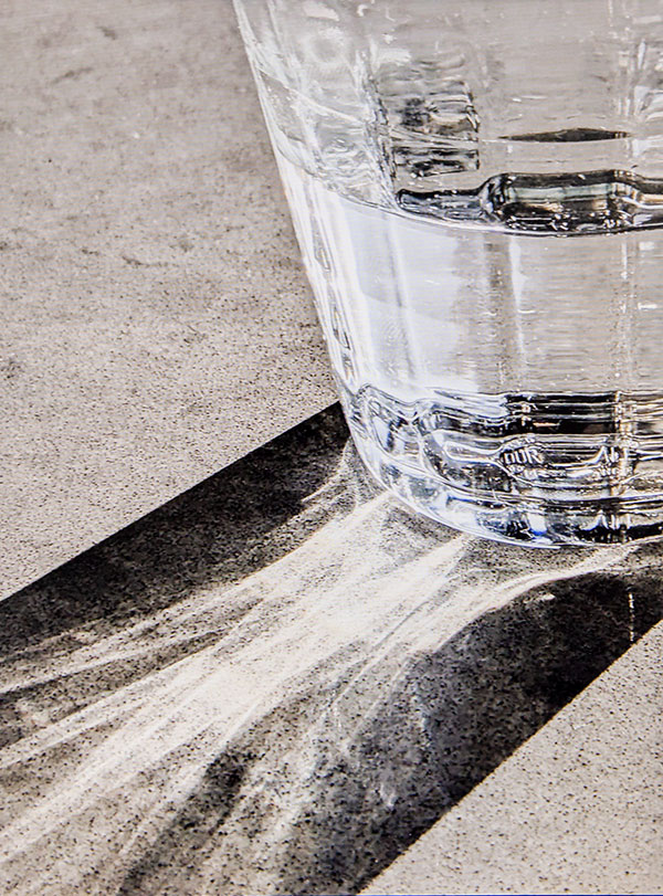 Photo of a backlit glass of water on a table with reflections and shadows by Jan Prislin-Planinc