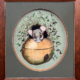 Polly Possum in the Pot - Ruth Quinn - Mixed Media. Possum's head peeping over the edge of a hanging pot surrounded by foliage. First Prize, People's Choice, PAS Open Studio & Exhibition, 2024