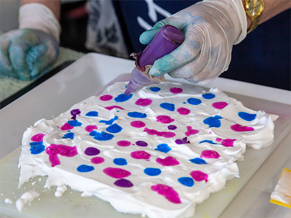 Marbling technique - applying patches of blue and pink paint to a layer of shaving foam