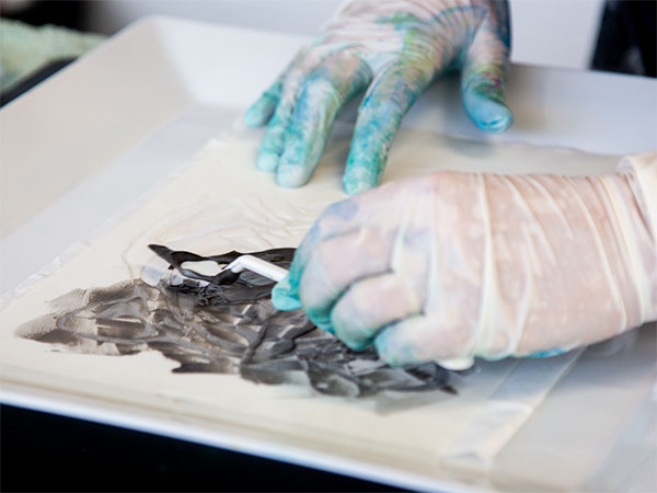 Stencilling technique - applying shaving foam mixed with black paint to stencil