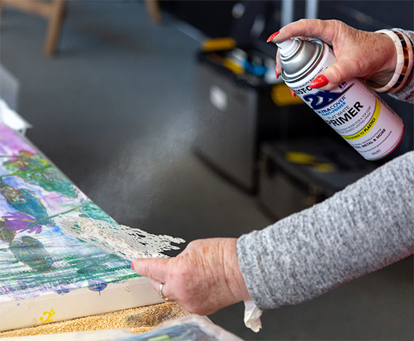 Spraying white paint through a stencil