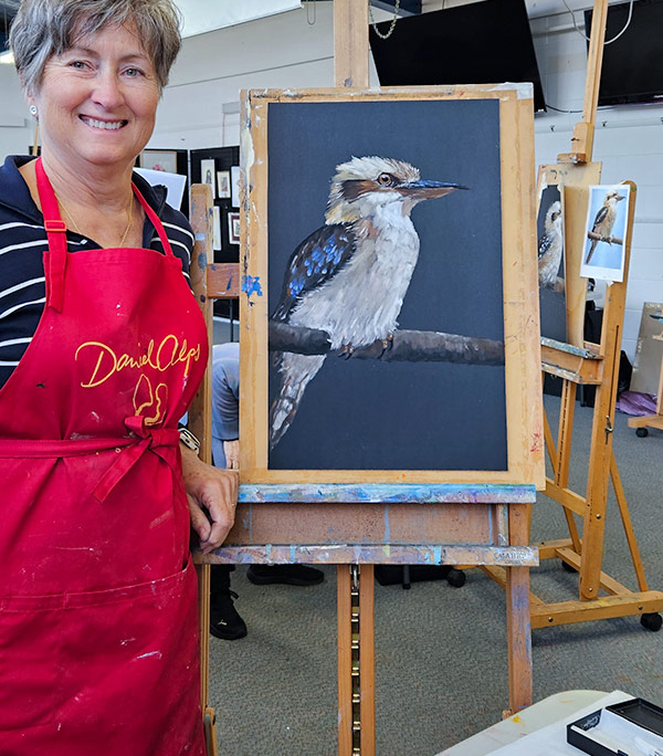 Angela Russo Pan Pastel Workshop participant- woman holding pastel painting of a kookaburra.