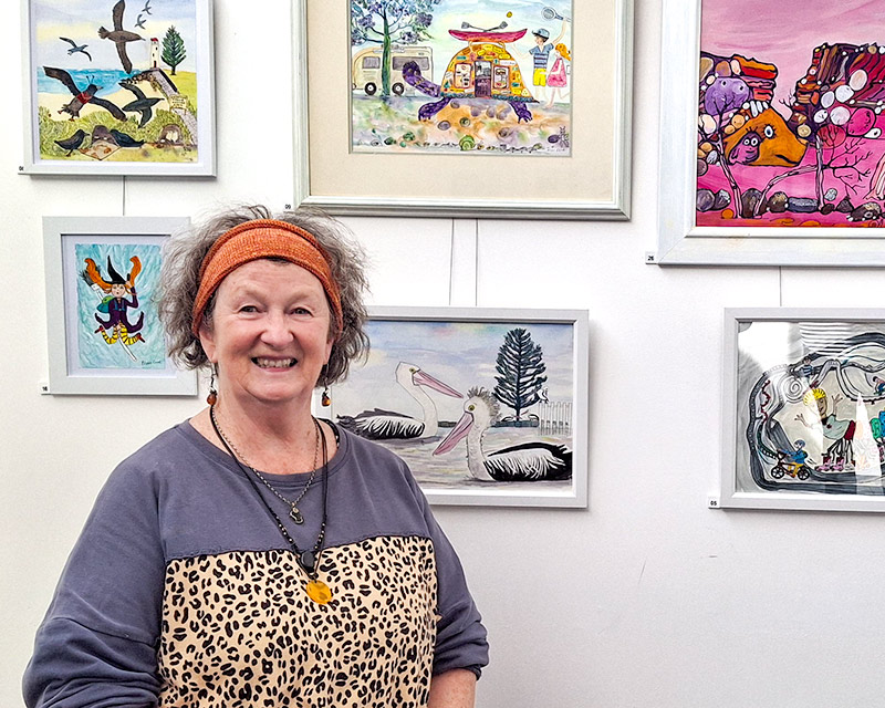 Eileen Curd Exhibition - Art for the Child Within. Photo of artist Eileen Curd with a selection of her artwork